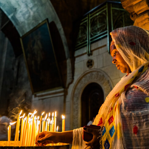 A Lady Burning Candles in Church