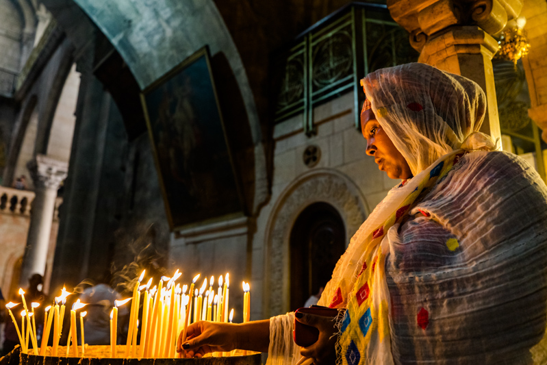 A Lady Burning Candles in Church